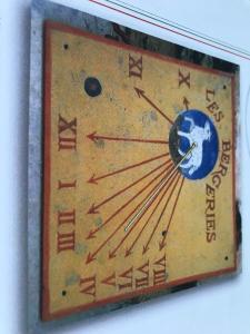 a clock on a wall with a planet on it at Les Bergeries in Tourrettes-sur-Loup