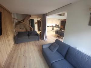 a living room with a blue couch and a kitchen at Résidence Luxe 5*,Spa & Fitness, La Cordée Appartement 821 in Chamonix-Mont-Blanc +29 photos