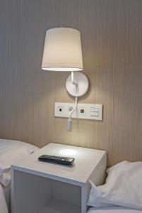 una mesa con una lámpara y un mando a distancia sobre ella en La Lonja, en Alicante