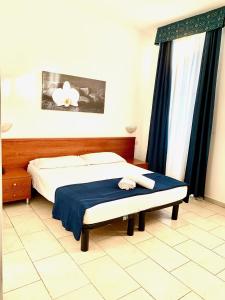 una camera con un letto e una coperta blu di Hotel Alessander a Milano