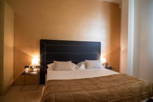 a bedroom with a large bed with two lamps on it at Hotel Europa in Palazzolo sullʼOglio