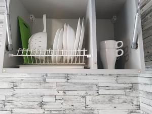 a cupboard filled with dishes and utensils at Пинск Brestskaia in Pinsk