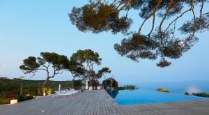 una piscina con sillas y vistas al agua en Villa Casa del Mar, en Sant Pere de Ribes