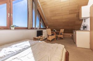 ein Schlafzimmer mit einem Bett und einem Tisch mit einer Küche in der Unterkunft Ostseehaus Petersen in Grömitz