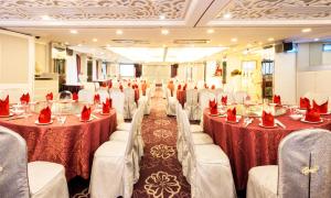 una sala banchetti con tavoli e sedie con tovaglioli rossi di Hotel Metropole a Macao