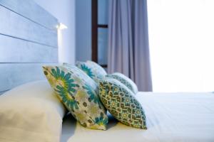 a group of pillows sitting on a bed at Hotel Avenida Playa in Zahara de los Atunes