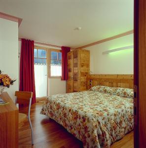1 dormitorio con cama y ventana en Hotel Ideal, en Madonna di Campiglio