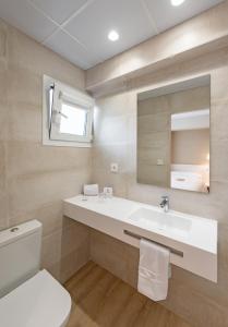 uma casa de banho com um lavatório, um WC e um espelho. em La Lonja em Alicante