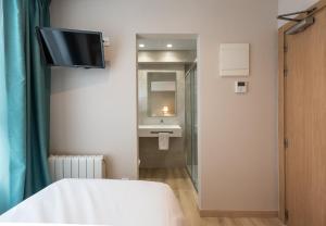 a room with a bed and a tv on the wall at La Lonja in Alicante
