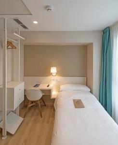 a small bedroom with a bed and a desk at La Lonja in Alicante