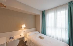Habitación de hotel con cama y ventana en La Lonja, en Alicante