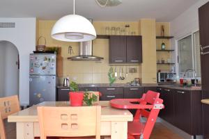 a kitchen with a table and chairs and a refrigerator at Disfruta Águilas in Águilas