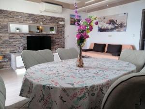 a dining room table with a vase of flowers on it at LibeTrogir in Trogir