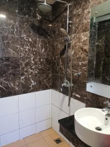 a bathroom with a sink and a shower at Fratini's Hotel Labuan in Labuan