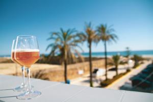 a glass of beer sitting on a table next to the beach at Hotel Avenida Playa in Zahara de los Atunes