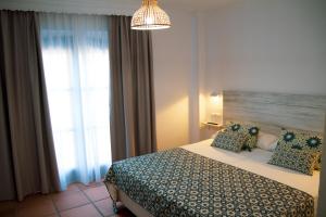 a bedroom with a bed and a large window at Hotel Avenida Playa in Zahara de los Atunes