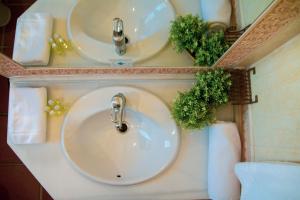 a bathroom with two sinks and two mirrors at Hotel Avenida Playa in Zahara de los Atunes
