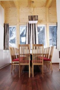 a dining room with a table and chairs and windows at Astellina hotel-apart in Ischgl