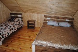 a room with two beds in a wooden cabin at Сімейний куточок in Svityazʼ