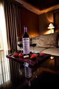 Una botella de vino y dos copas en una mesa. en Nexus Valladolid Suites & Hotel en Valladolid