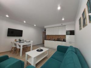 salon z niebieską kanapą i stołem w obiekcie Apartament Przy Lesie Słoneczne Tarasy w Dziwnówku