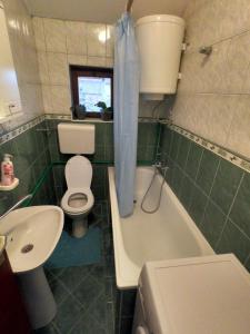 La salle de bains est pourvue de toilettes, d'une baignoire et d'un lavabo. dans l'établissement Moj salaš, à Novi Sad