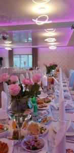 a long table with plates of food and flowers on it at Route One - Restauracja & Pokoje Hotelowe in Zgierz