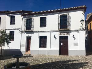 un edificio blanco con una puerta y ventanas marrones en Tranquilo Apartamento en el corazón del Albaicín, en Granada