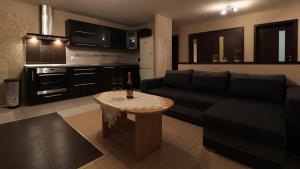 Sala de estar con sofá y mesa con botella de vino en Apartmán Silvia, en Pribylina