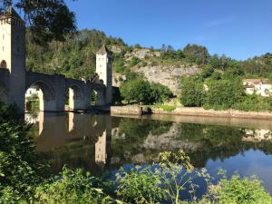 a castle and its reflection in the water at Best Western Plus Hotel Divona Cahors in Cahors