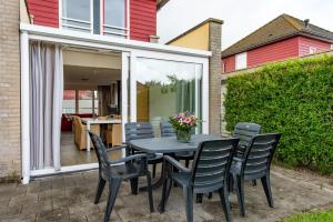 ein schwarzer Tisch und Stühle auf einer Terrasse in der Unterkunft Maxime 207 - Kustpark Village Scaldia in Hoofdplaat