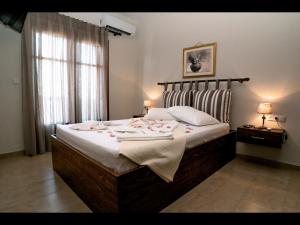 スカラ・カリラキスにあるStelios Apartmentsのベッドルーム1室(花の咲く大型ベッド1台付)