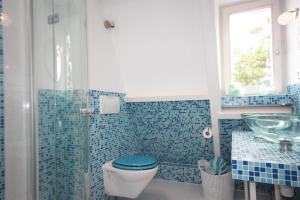 Baño de azulejos azules con aseo y lavamanos en De Pimpelmees, en La Haya