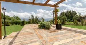 ValleにあるJOIVY Superb Villas with Tennis Court, Garden and BBQ areaの庭の石畳の通路付きパティオ