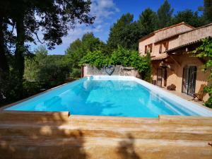 uma grande piscina azul em frente a uma casa em Guestazur Draguignan em Draguignan