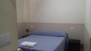 a small bedroom with a bed with a blue blanket at OK Roma in Rome