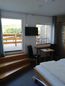a bedroom with a bed and a desk and a window at Pension "Dorfkrug" in Winterberg