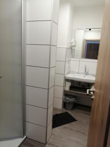 ein Bad mit einem Waschbecken und einem Spiegel in der Unterkunft Pension "Dorfkrug" in Winterberg