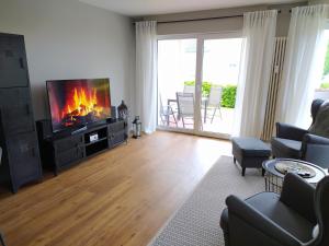 een woonkamer met een flatscreen-tv en een open haard bij Ferienwohnung Meeresbucht in Sassnitz