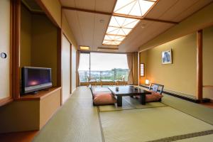 a living room with a table and a tv at Shintomi-tei in Matsushima