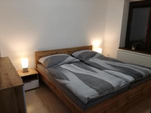 1 dormitorio con 1 cama con 2 lámparas y TV en Apartmán Silvia, en Pribylina