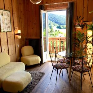 um quarto com uma mesa e cadeiras e uma varanda em Hôtel des Skieurs em Le Sappey-en-Chartreuse