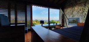 ein Schlafzimmer mit einem Bett und einem großen Fenster in der Unterkunft AltaVista in Vitorino dos Piães