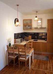 ヘウムにあるStylowy Apartament w Kamienicyのキッチン(木製のテーブル、椅子、カウンター付)