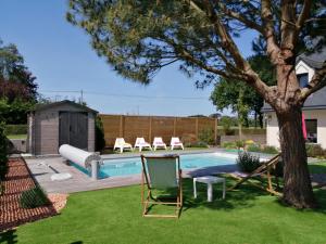 a backyard with a pool with chairs and a tree at LES VILLAS TAGARINES - Villa Du Pin in Étables