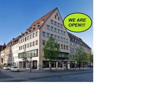 a building with a sign that says we are open at Sorat Hotel Saxx Nürnberg in Nuremberg