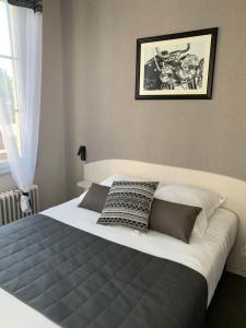 a large bed in a bedroom with a picture on the wall at L'Escale de la Gare in Saumur