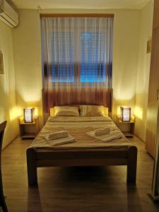 a bedroom with a large bed with two towels on it at Apartments Take a Break Novi Sad in Novi Sad