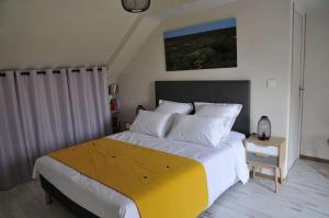 - une chambre avec un grand lit et une couverture jaune dans l'établissement Laboucaliniere, à Plurien
