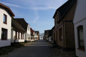 une rue vide dans un village avec des bâtiments dans l'établissement Altes Fischerhaus, à Maasholm